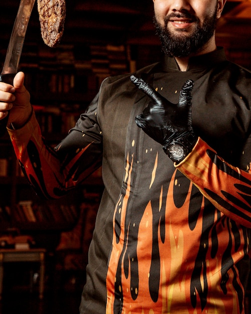 Free photo chef holds fried meat on knife