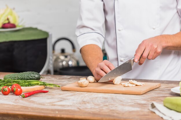 Chef in kitchen cooking with vegetables