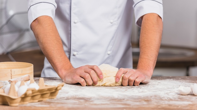 Chef in kitchen making dough