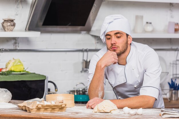 Chef in kitchen making dough