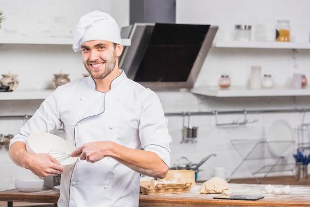 Free photo chef in kitchen making dough