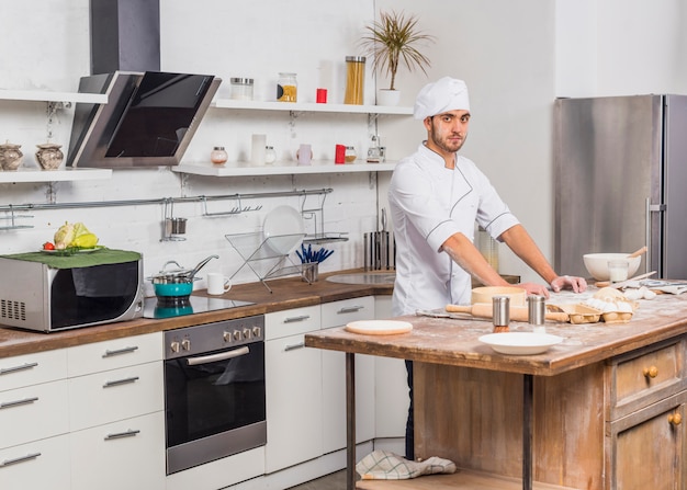 Foto gratuita chef in cucina a preparare l'impasto