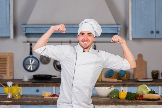 Chef in kitchen in strong pose