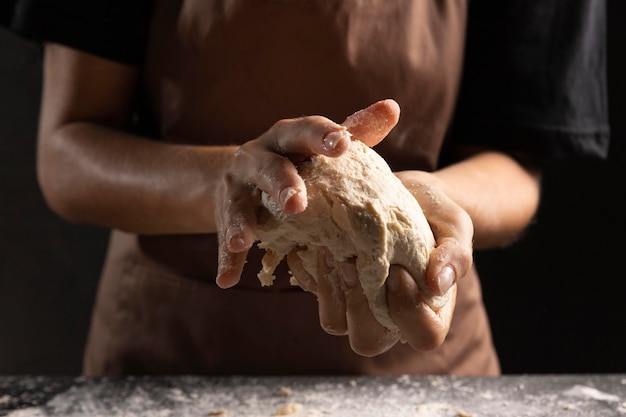 Chef kneading bread dough in hands