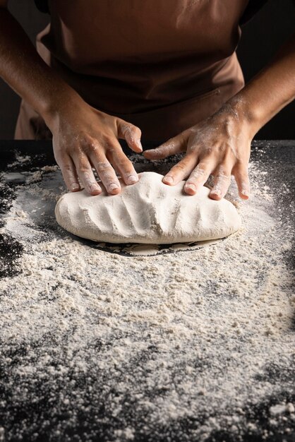 Chef kneading dough on the table