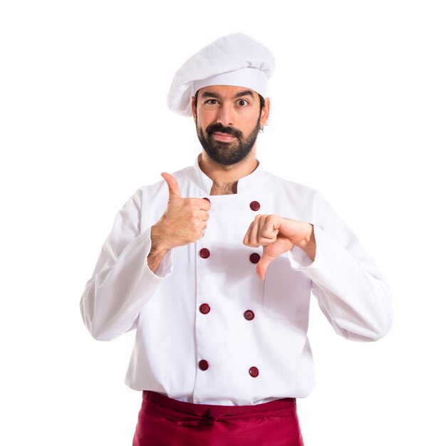 Chef making a good-bad sign over white background