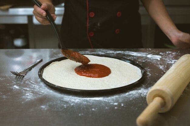 chef making pizza at kitchen