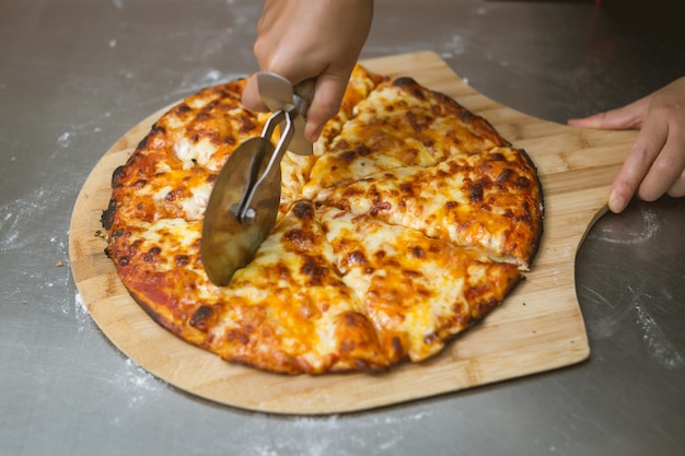 Foto gratuita chef a preparare la pizza in cucina