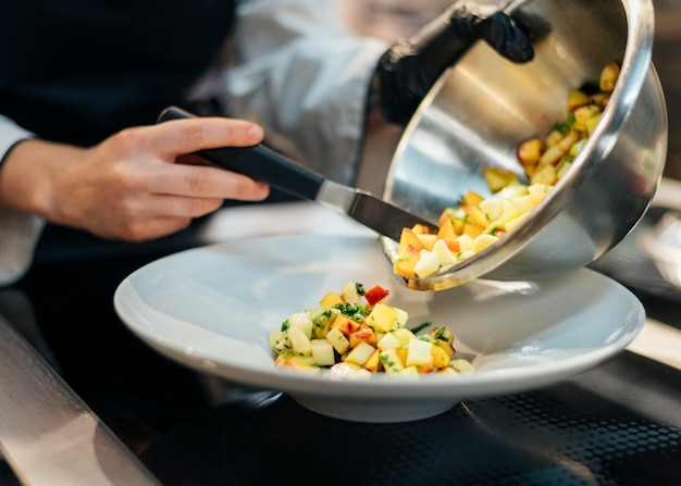 Chef pouring food on plate