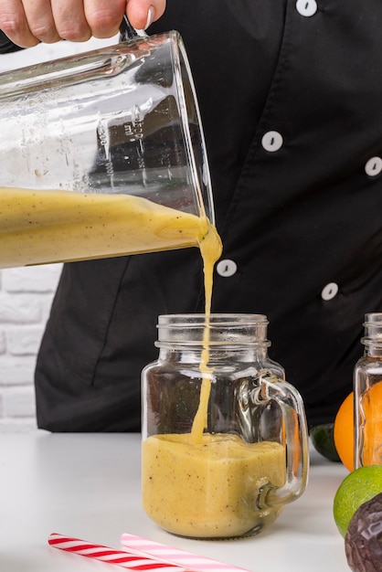 Free photo chef pouring juice in jar