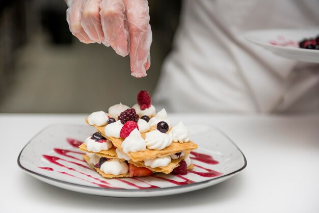 Chef preparing tasty dessert close up