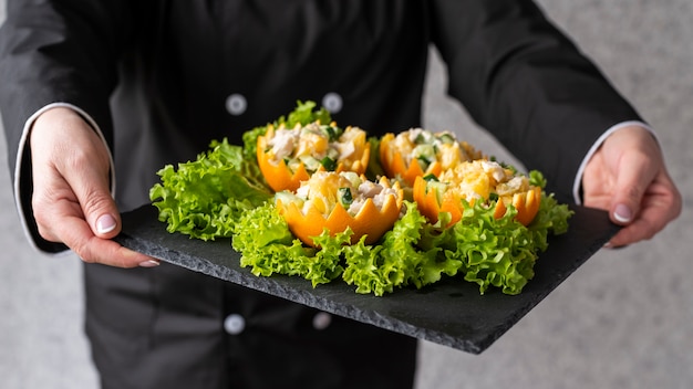 Free photo chef presenting dish on slate