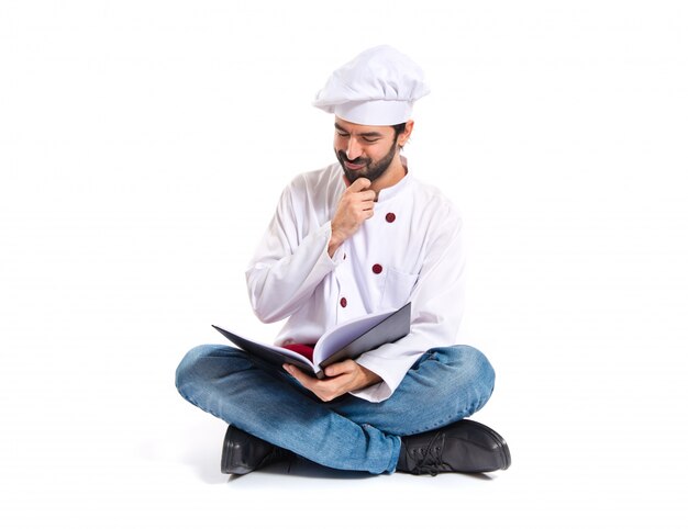 Шеф-повар, чтение книги на белом фоне
