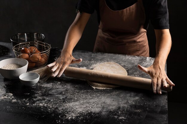Chef rolling dough in the table