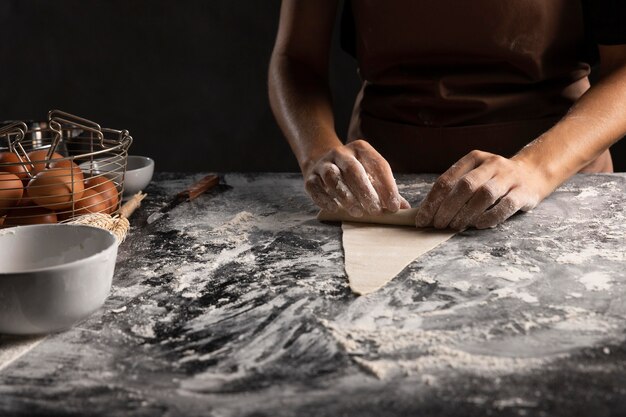 Chef rolling dough triangle for croissant