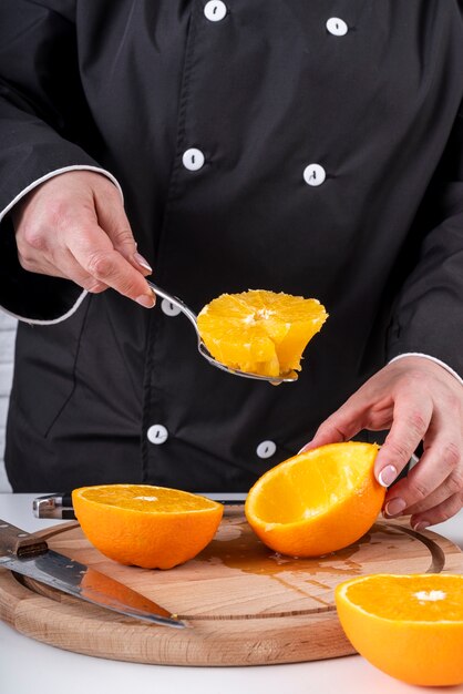 Chef scooping oranges
