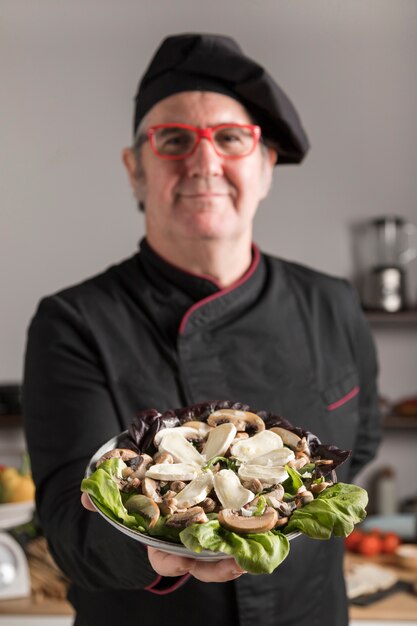 Chef showing plate with food for camera