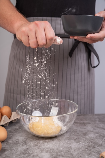 Chef sprinking flour on dough