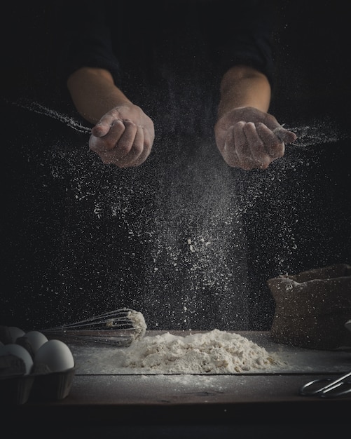 Free photo chef sprinkling flour