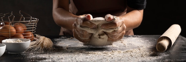 Chef using hands to knead the dough