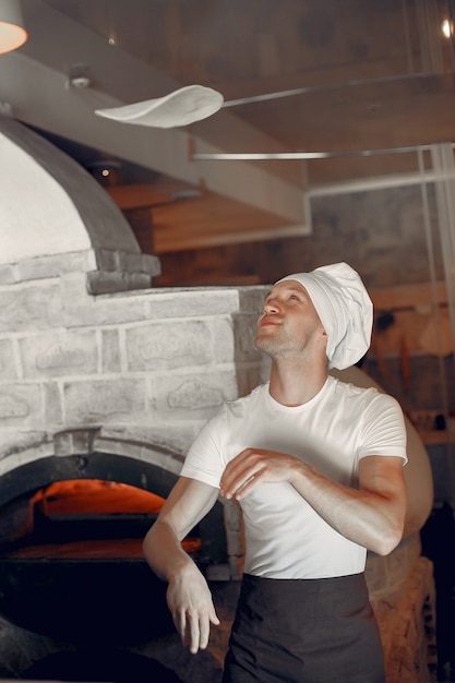 Free photo chef in a white uniform prepare a pizzaa