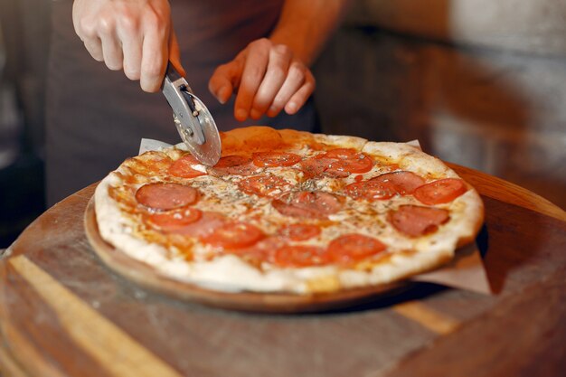 흰색 유니폼을 입고 요리사는 pizzaa를 준비