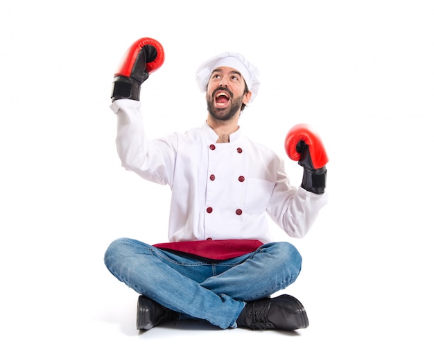 Chef with boxing gloves sitting on the floor