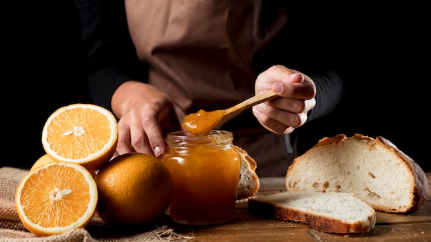 Foto gratuita chef con barattolo di marmellata di arance