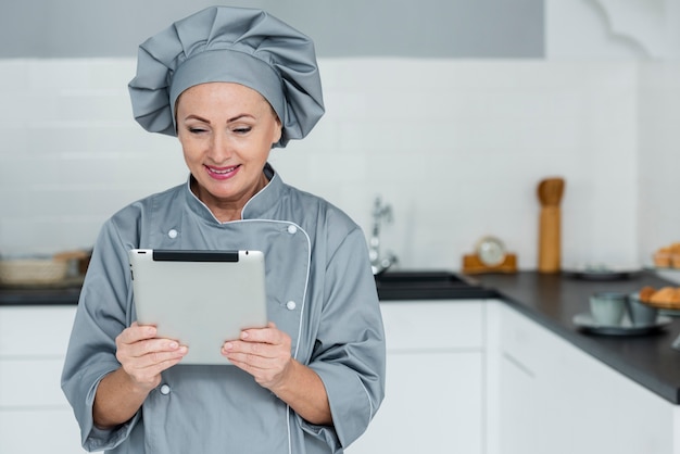 Foto gratuita chef con tavoletta in cucina