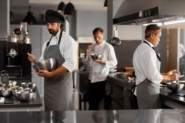 Foto gratuita chef che lavorano insieme in una cucina professionale