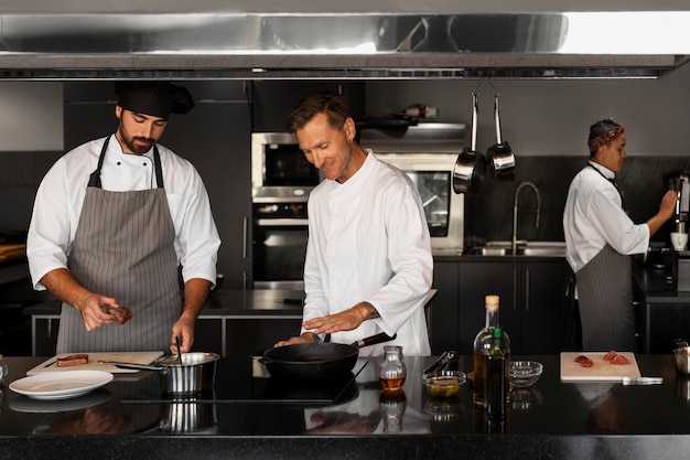 Foto gratuita chef che lavorano insieme in una cucina professionale