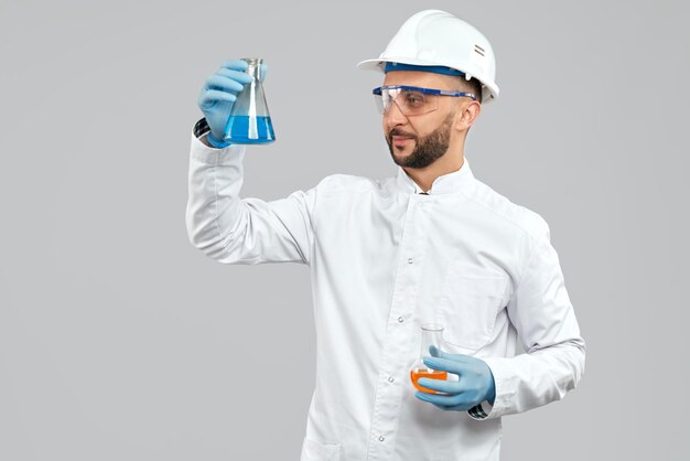 Chemist holding flasks with liquid