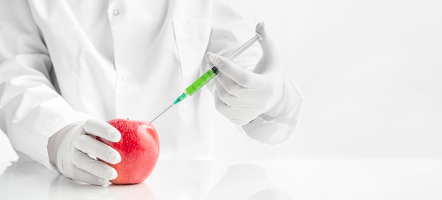 Chemist injecting with toxins a perfect healthy apple