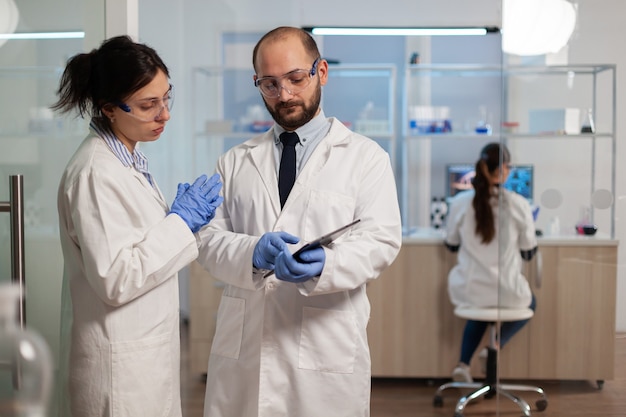 Infermiere chimico che spiega al medico lo sviluppo del vaccino in un moderno laboratorio