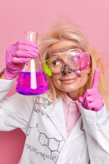  chemistry sphere demonstrates her results and achievements being chemical research specialist performs various experiments dressed in uniform isolated on pink 