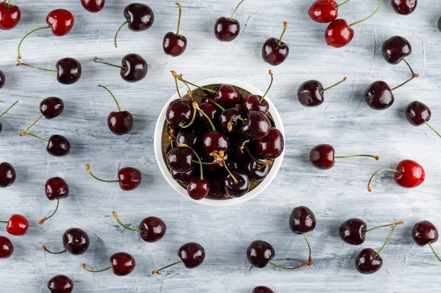 Cherries in a bowl flat lay on a grunge surface