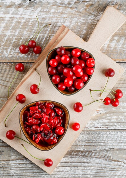 Cherries in a bowl with jam on wooden and cutting board