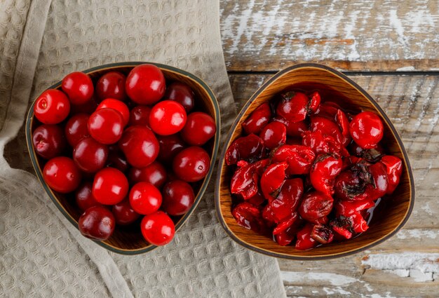 Cherries in bowl with jam on wooden and kitchen towel..