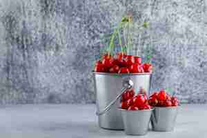 Free photo cherries in buckets. side view.