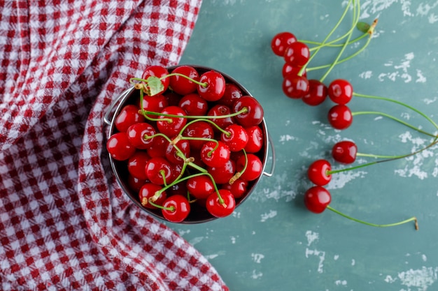 Бесплатное фото Вишни в ведре плоско уложить на гипс и кухонное полотенце