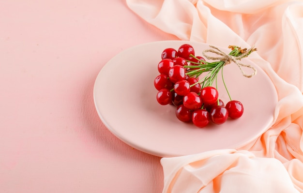 Free photo cherries in a plate, high angle view.