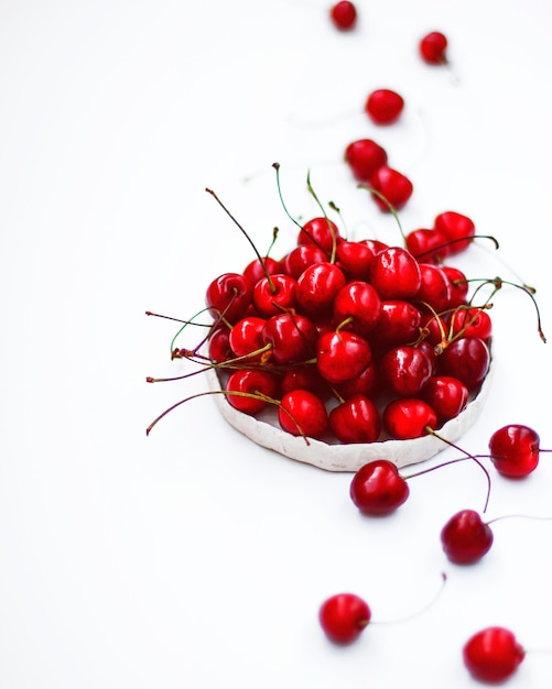 Cherries in white handmade ceramic rustic bowl. 