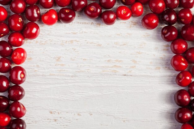 Cherries on white wooden table with copyspace available. Raw organic food