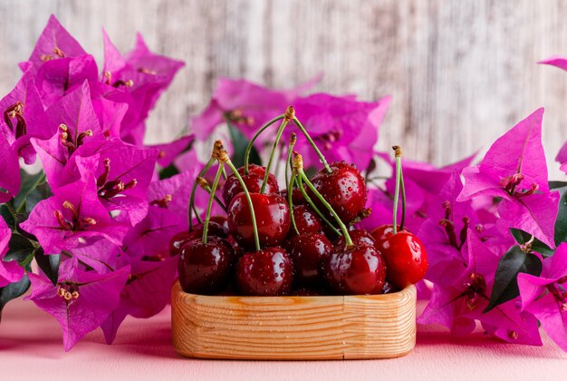 ピンクと汚れた表面の花の側面図で木の板のさくらんぼ