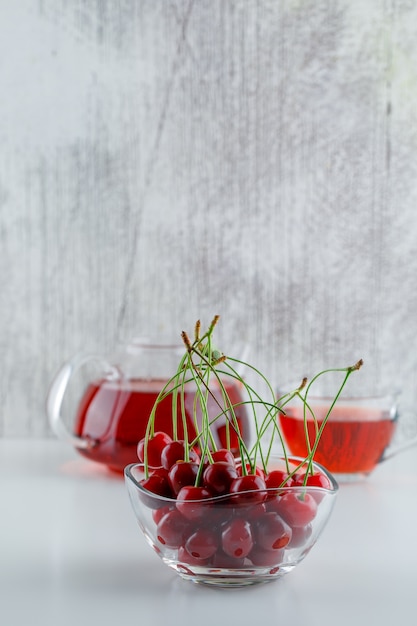 Cherry in a bowl with tea side view