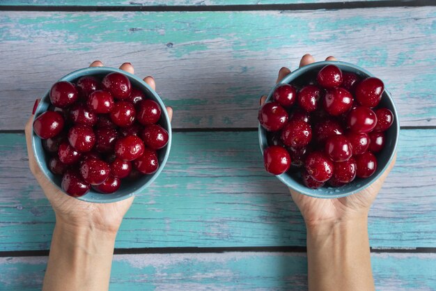 Free photo cherry bowles in the hands of a person