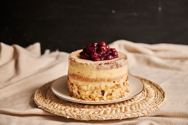 Torta di ciliegie con crema su un piatto bianco con uno sfondo sfocato