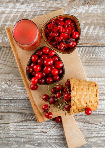 Cherry drink in a jug with cherries, jam on wooden and cutting board