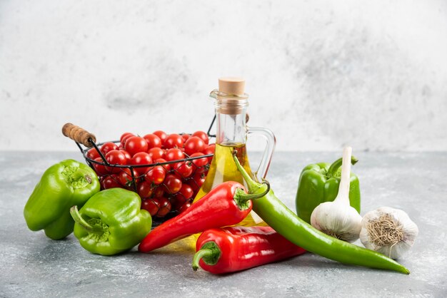 Cherry tomatoes in basket with chili peppers, garlic and olive oil.