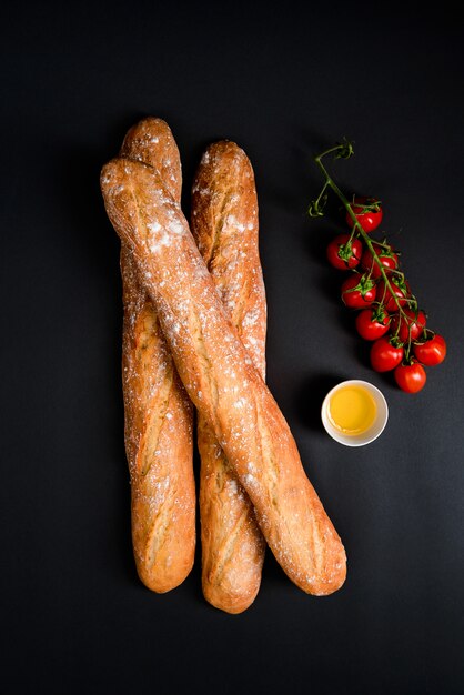 Cherry tomatoes, oil and long loafes with flour.